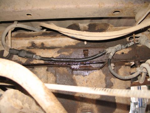 1995 Ford Bronco - Close-up of the vehicle's undercarriage, showing fuel lines and wiring harness.