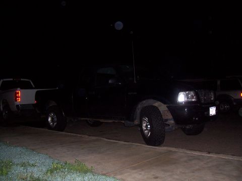 2003 Ford Ranger - A black 2003 Ford Ranger pickup truck is parked on a driveway at night, with another truck visible to the left.