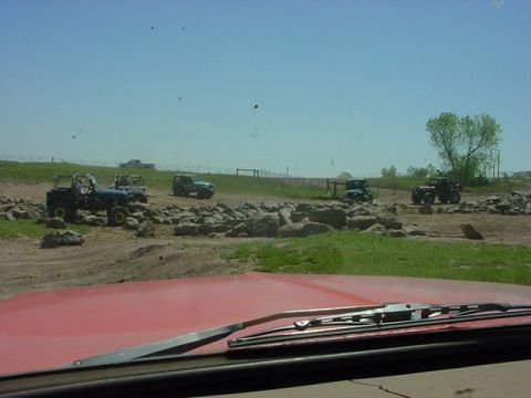 1979 Ford Bronco - Multiple off-road vehicles navigate a challenging terrain course on a sunny day.