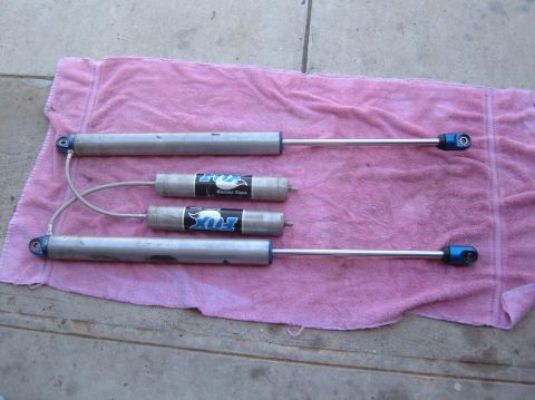 1985 Ford Bronco II - Four Fox Racing Shox, two with external reservoirs, are displayed on a pink towel.