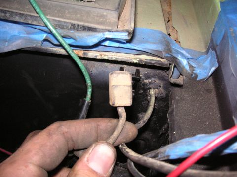 1999 Jeep Grand Cherokee - Close-up of a hand manipulating a wiring harness connector in a vehicle's interior.