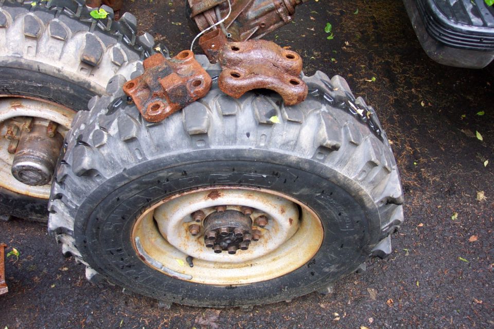 Rusty metal brackets and large tires with aggressive tread