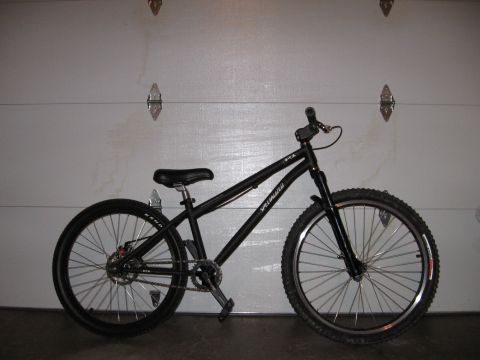 1997 Ford Probe - A black Specialized bicycle is shown in a garage, leaning against a closed garage door.