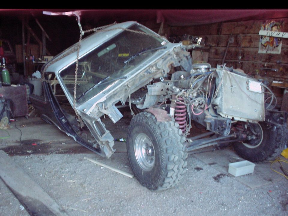 1984 Ford Bronco body, front end removed, suspended by chains