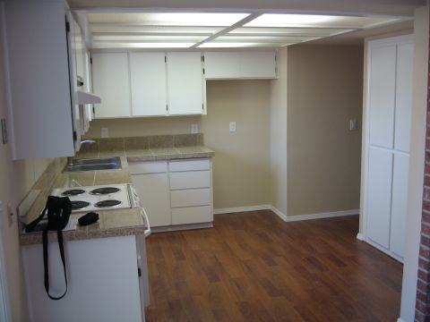 1994 Ford Probe - This kitchen features white cabinetry, speckled granite countertops, and a wood-look laminate floor.
