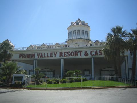 1990 Ford Bronco - Primm Valley Resort & Casino, a white building with a central tower and large portico, under a clear blue sky.