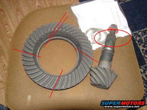 1979 Ford Bronco - Differential ring gear and pinion shaft with bearings are laid out on a textured surface.