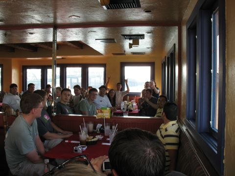 1997 Ford Probe - A group of people are seated at tables inside a restaurant, with some standing and interacting.