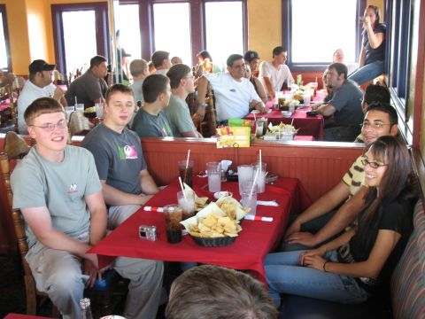 1997 Ford Probe - Diners enjoy chips and drinks at tables inside a restaurant with large windows.