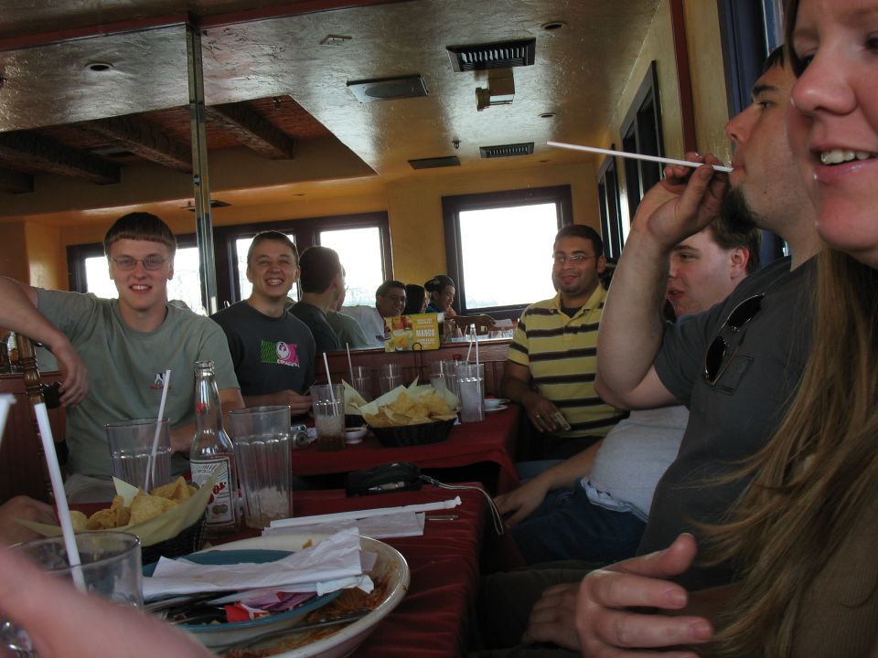 People sitting at tables in a restaurant, some smiling and talking
