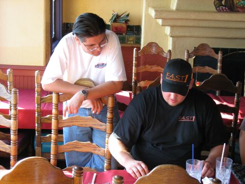 1997 Ford Probe - Two men are seen at a table in a restaurant, both wearing apparel with the "FAST1" logo.