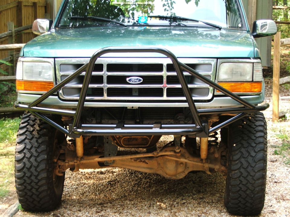 Green Ford Bronco front end with aftermarket brush guard and large off-road tires
