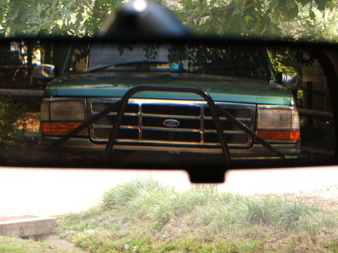 1996 Ford Bronco - A green Ford Bronco is seen from the front, equipped with a black bull bar and chrome grille.