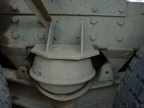1979 Ford Bronco - Close-up view of a truck's suspension system, focusing on a large rubber isolator and metal brackets.