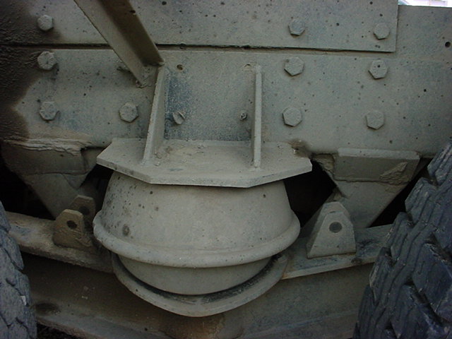 Truck chassis suspension component with visible bolts and rubber isolator