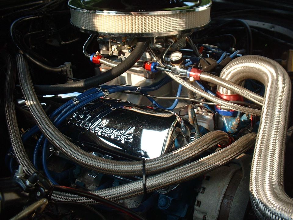 Chrome Eldelbrock valve cover and braided hoses in engine bay