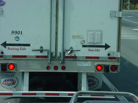 1979 Ford Bronco - The rear of a trailer displays directional text, indicating 'Passing Side' and 'Suicide'.
