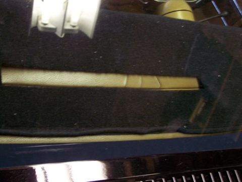 1975 Chevrolet Corvette - Close-up of a car's dashboard interior, showing a tan strip against black carpeting.