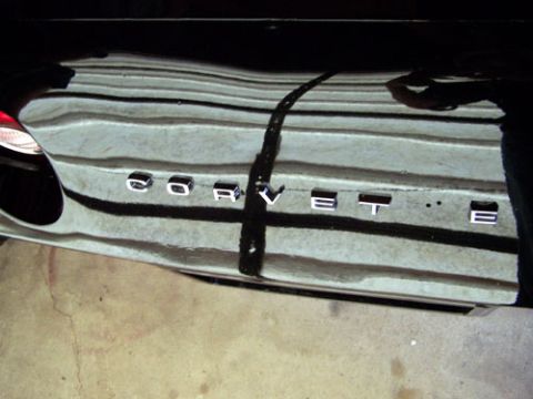 1975 Chevrolet Corvette - The rear of a black car displays "CORVETTE" badging.