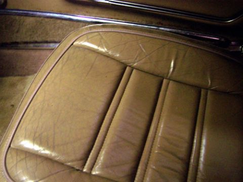 1975 Chevrolet Corvette - Close-up of a tan leather interior seat, showing stitching and wear marks.