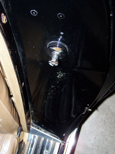 1975 Chevrolet Corvette - Close-up of the interior door latch mechanism on a 1975 Chevrolet Corvette, with a tan seat in view.