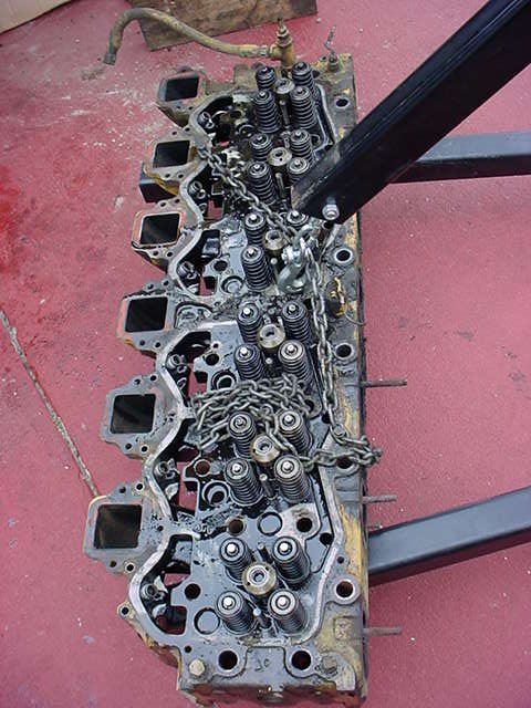 1979 Ford Bronco - Engine cylinder head with chains and valve springs, likely removed for repair or rebuilding.