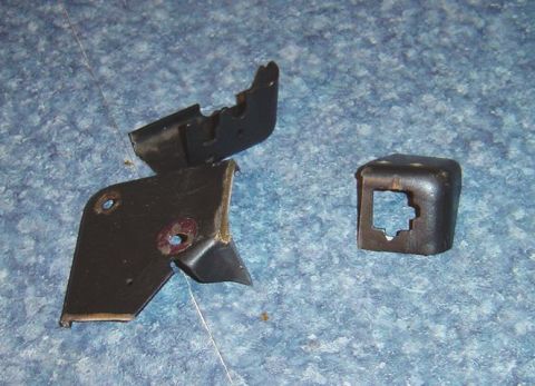 1986 Ford Bronco - Several metal brackets are shown on a textured blue surface.