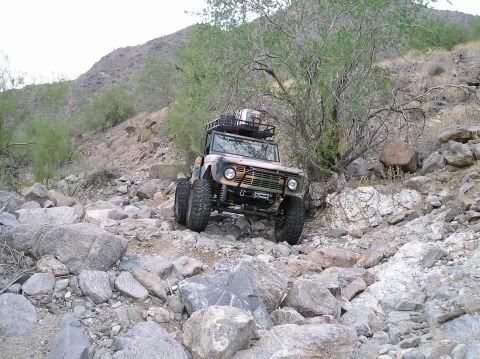1993 Ford Bronco - A classic Ford Bronco navigates a challenging rocky terrain on a steep incline.