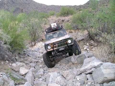 1993 Ford Bronco - A modified Ford Bronco tackles a challenging rocky terrain on an off-road adventure.