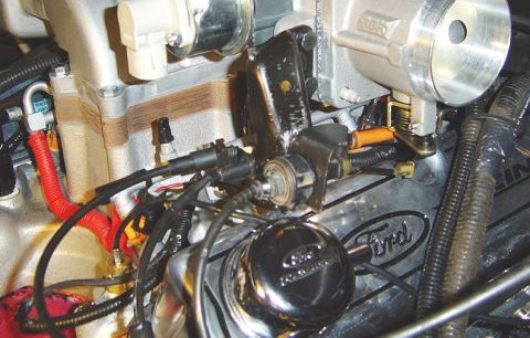 1986 Ford Bronco - Close-up of a throttle bracket assembly on a Ford engine, with the year '1986' visible on a badge.
