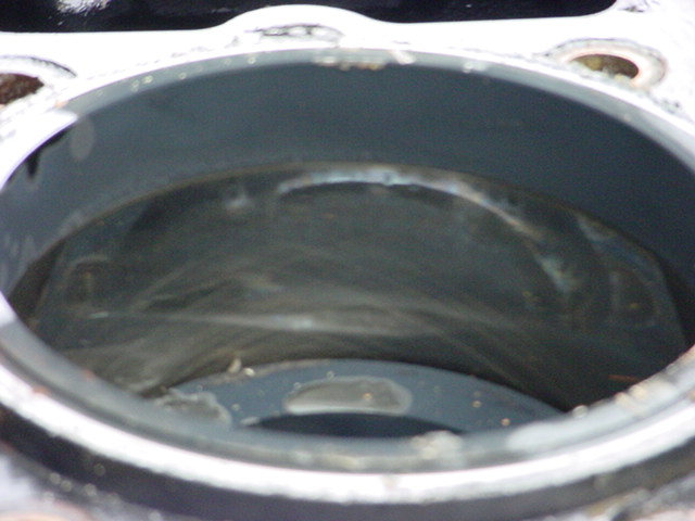 Engine cylinder with visible scoring and residue inside. Watermark reads SUPERMOTORS