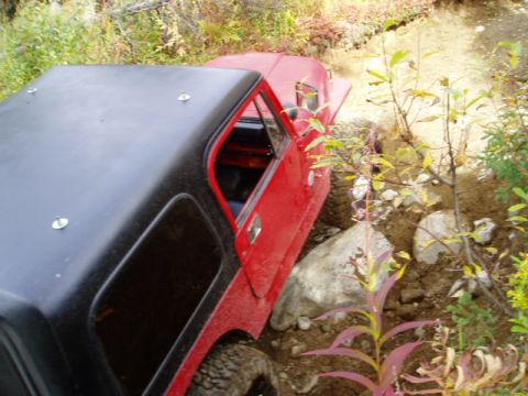 2000 Ford E350 - Red off-road vehicle with black hardtop is shown on a challenging rocky trail.