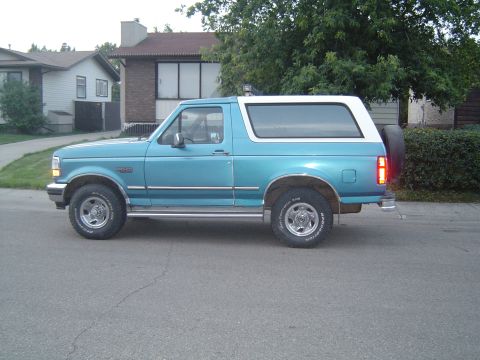 1995 Ford Bronco - This blue and white Ford Bronco is seen from the side on a suburban street.