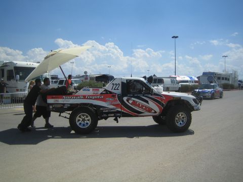 1990 Ford Bronco - red, white and black number-722 trophy truck with Norwalk Toyota livery sits with its hood raised in a paved pit area.