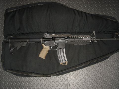1990 Ford Bronco - An assault rifle is displayed inside a black padded gun case on a textured surface.