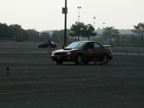 2001 Mercury Grand Marquis - A red sedan with racing number 170 navigates a course marked by cones, with another car visible in the background.