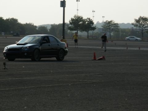 2001 Mercury Grand Marquis - A black Subaru Impreza WRX sedan is seen on a track during an event, with cones marking the course.