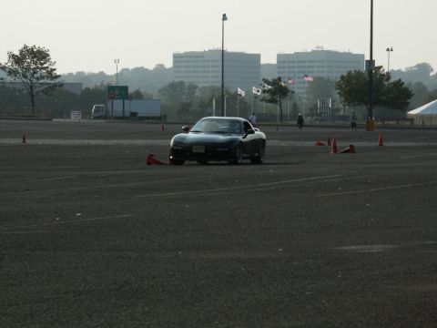 2001 Mercury Grand Marquis - A black sports car navigates a course marked by orange cones in an open lot.