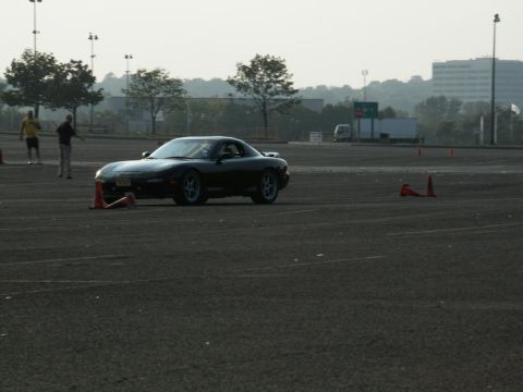 2001 Mercury Grand Marquis - A black sports car navigates a course marked by orange cones on a paved track.
