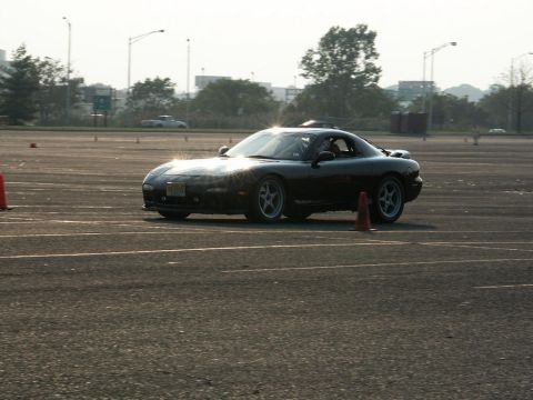 2001 Mercury Grand Marquis - A black sports car navigates a course marked by orange cones under a hazy sky.