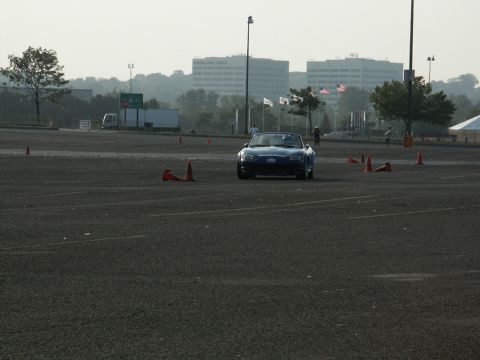 2001 Mercury Grand Marquis - A blue convertible sports car navigates a course marked by orange cones in an open paved area.