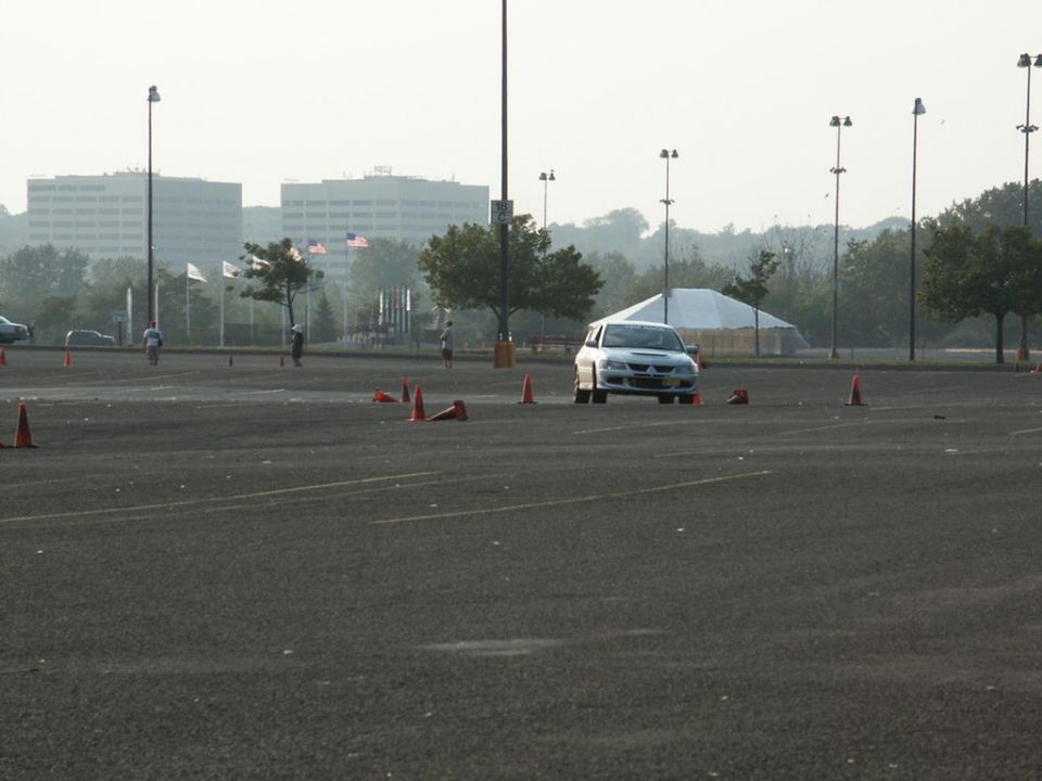 White sedan with racing decals on a track with cones