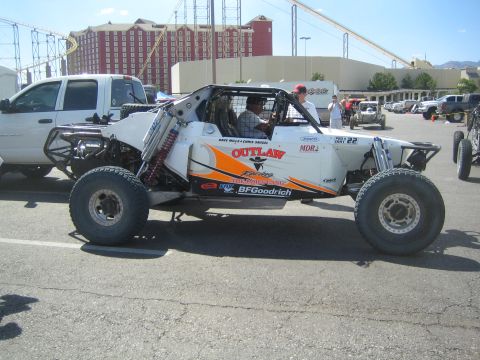1990 Ford Bronco - white single-seat tube-chassis Outlaw race buggy number 22 with BFGoodrich and Fox graphics parked on pavement.