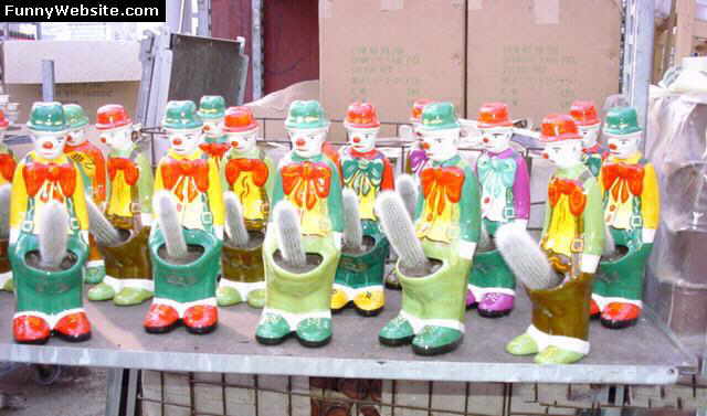 Row of colorful clown planters holding cacti on a shelf