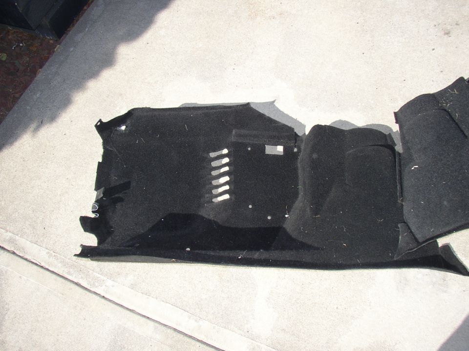 Black car floor carpet with molded sections and metal clips