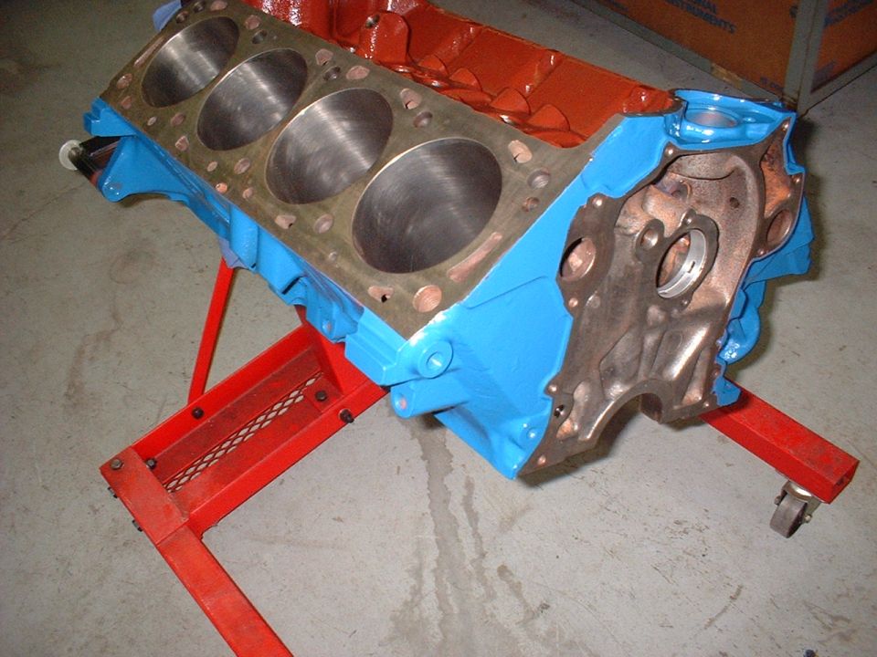 Blue and orange engine block on a red stand. Cylinders are visible