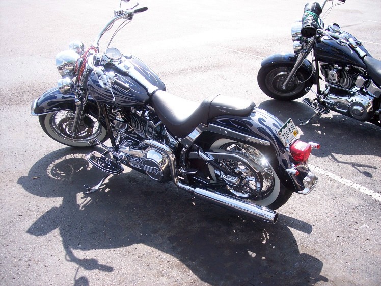 Two Harley-Davidson motorcycles parked, one in foreground with flame paint, one behind