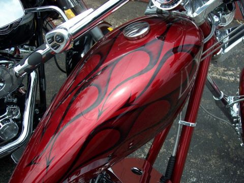 1972 Ford Ranchero - Close-up of a motorcycle's red gas tank black flame graphics and a chrome gas cap.