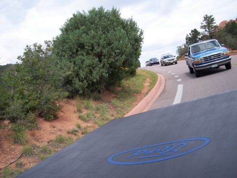 1972 Ford Ranchero - A car navigates a winding road surrounded by vegetation.
