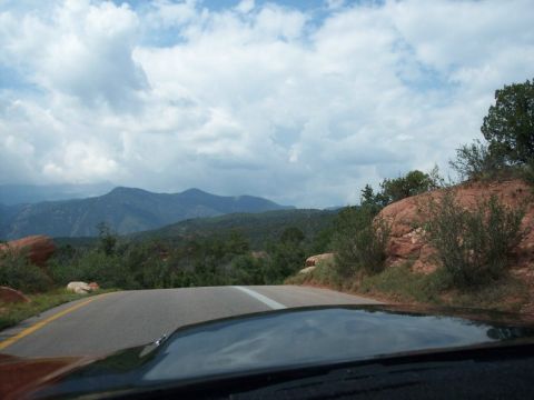 1972 Ford Ranchero - A scenic view from inside a vehicle, looking out at a cloudy sky and mountainous terrain.